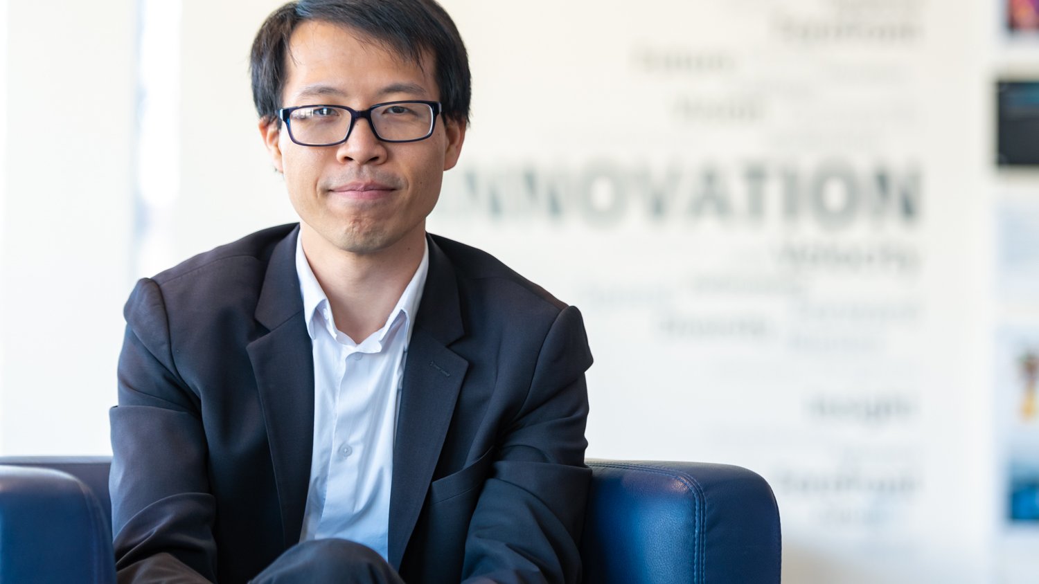 A portrait of Peter Hung seated facing camera