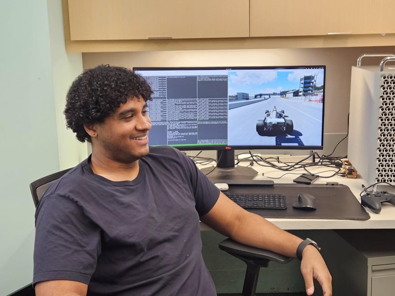 Gilchrist Johnson sitting in front of his computer, showing race car simulations