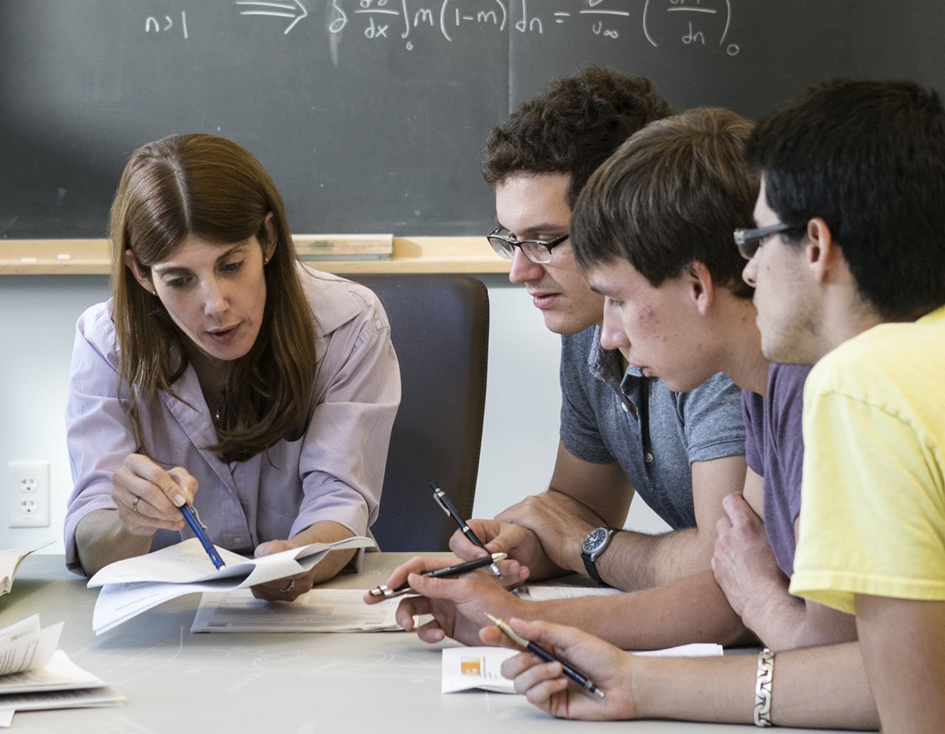 A group of Caltech students engage in a classroom discussion